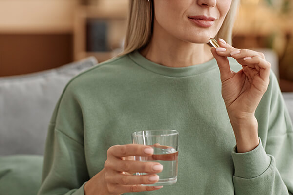 Nahrungsergänzungsmittel kaufen und mit Wasser einnehmen Eine Frau kann Nahrungsmittel kaufen und mit Wasser einnehmen
