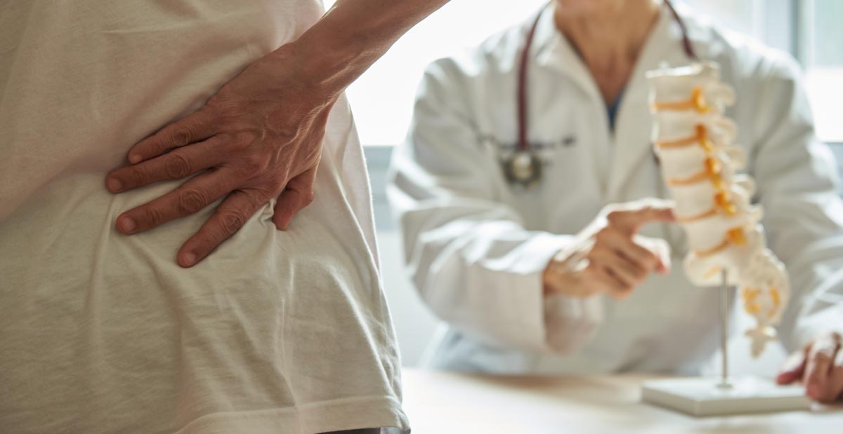 Ein Arzt versucht anhand der Patientenaussagen den Rückenschmerz zu kategorisieren