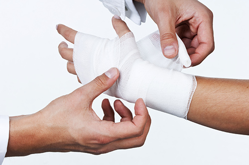 Polsterbinde wird bei der Bandagierung benutzt Arzt wickelt eine Bandage mit Polsterbinde