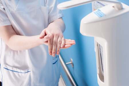 Krankenschwester desinfiziert Hände