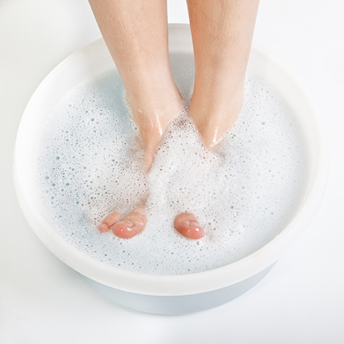 Füße werden in Fußbadewanne gebadet