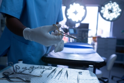 Ein Arzt greift nach seinem medizinischen Equipment – es wurde in einer schülke Instrumentenwanne gereinigt