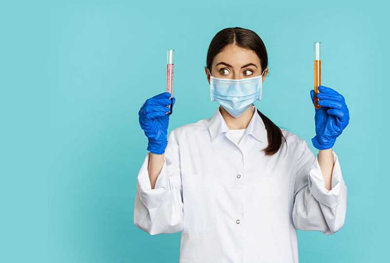 Schnelltests von CLEARTEST Ärztin hält zwei Laborproben in den Händen