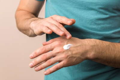schülke Waschen und Pflegen Serie nNhaufnahme eines Mannes der seine Haende mit schülke Skin Care eincremt